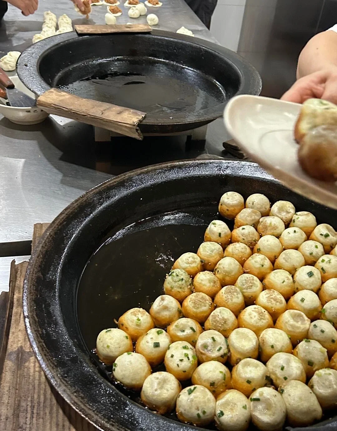 Suzhou Pan Fried Buns Fresh shengjian mantou cooked in large iron pans - What to Eat in Suzhou: Local Food Guide 2026 - The China Journey Suzhou Pan Fried Buns Fresh shengjian mantou cooked in large iron pans - What to Eat in Suzhou: Local Food Guide 2026 - The China Journey