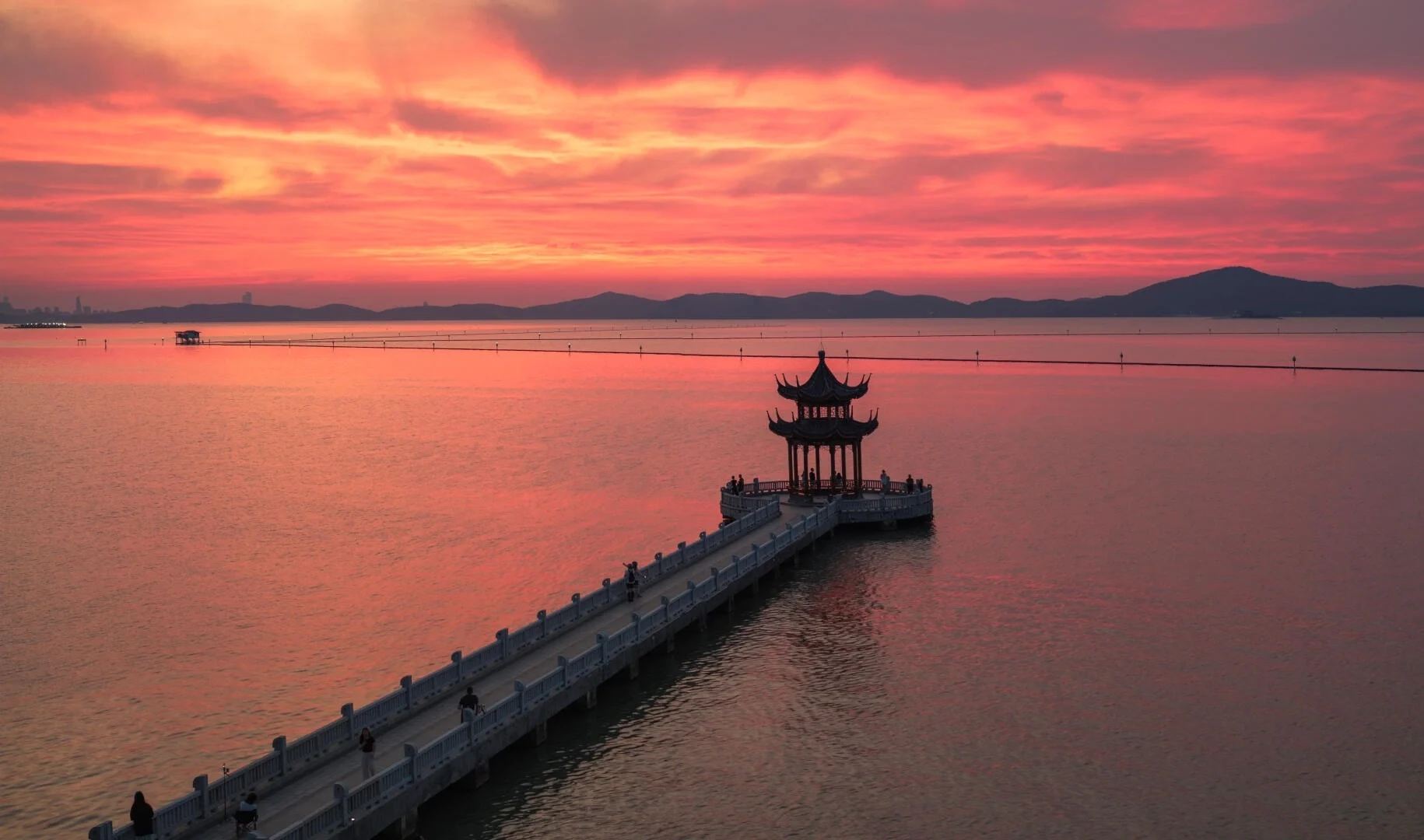 Pavillon ved solopgang ved Taihu-søen i Wuxi, traditionel kinesisk pavillon over vandet med glødende rød himmel og rolig morgenrefleksion - Wuxi rejseguide: Bedste rejseplan og tips 2026 - The China Journey Pavillon ved solopgang ved Taihu-søen i Wuxi, traditionel kinesisk pavillon over vandet med glødende rød himmel og rolig morgenrefleksion - Wuxi rejseguide: Bedste rejseplan og tips 2026 - The China Journey