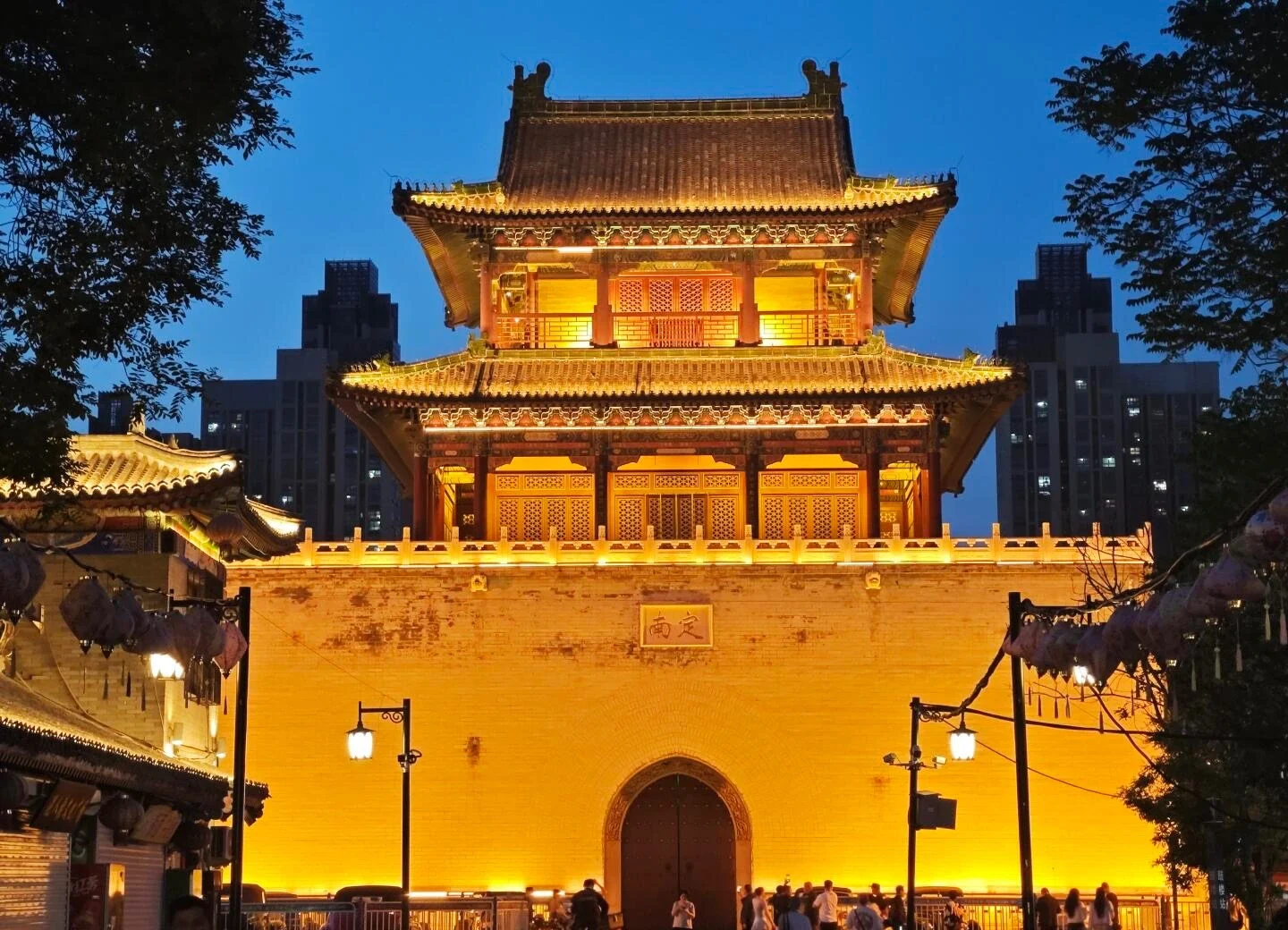 Vista noturna da Torre do Tambor de Tianjin iluminada: arquitetura tradicional chinesa que combina o charme histórico com o horizonte moderno da cidade - Onde ficar em Tianjin: Melhores áreas e hotéis em 2026 - A Jornada pela China Vista noturna da Torre do Tambor de Tianjin iluminada: arquitetura tradicional chinesa que combina o charme histórico com o horizonte moderno da cidade - Onde ficar em Tianjin: Melhores áreas e hotéis em 2026 - A Jornada pela China