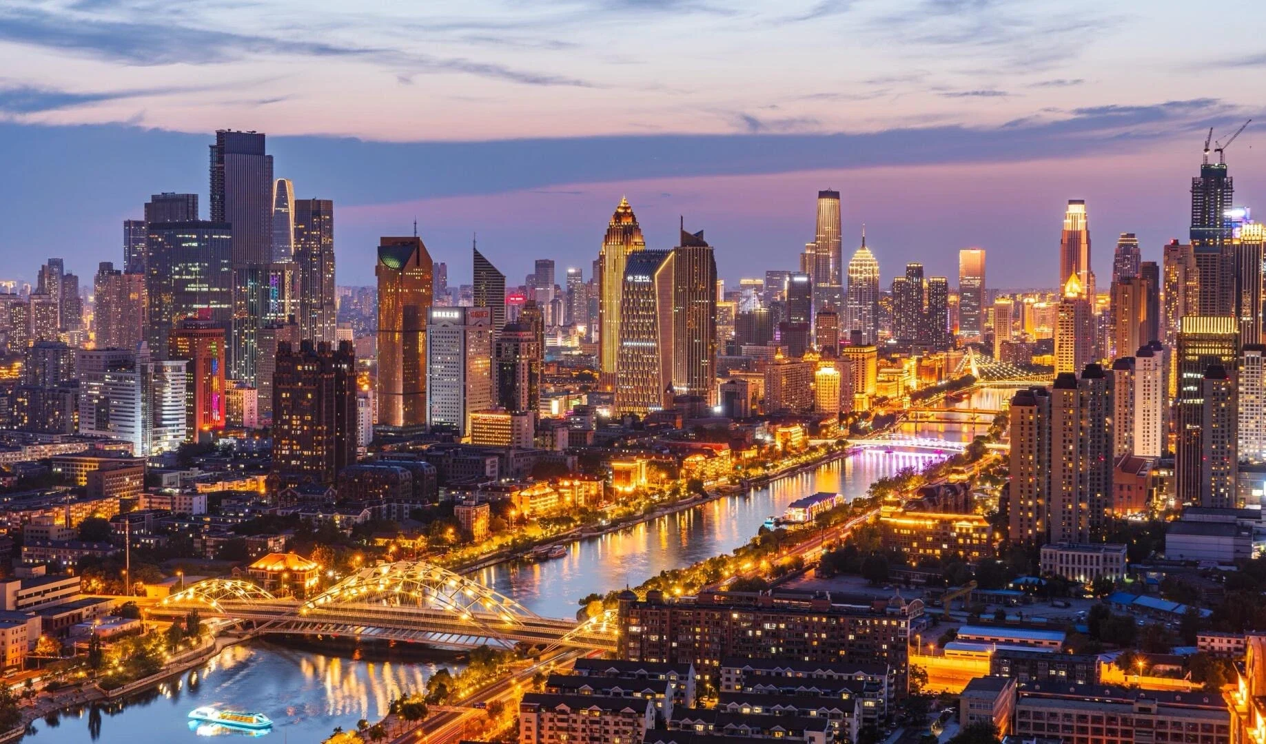 Vista deslumbrante do horizonte da Praça Jinwan em Tianjin, com o Rio Haihe, pontes, arranha-céus e as luzes coloridas da cidade à noite - Onde ficar em Tianjin: Melhores áreas e hotéis em 2026 - The China Journey Vista deslumbrante do horizonte da Praça Jinwan em Tianjin, com o Rio Haihe, pontes, arranha-céus e as luzes coloridas da cidade à noite - Onde ficar em Tianjin: Melhores áreas e hotéis em 2026 - The China Journey