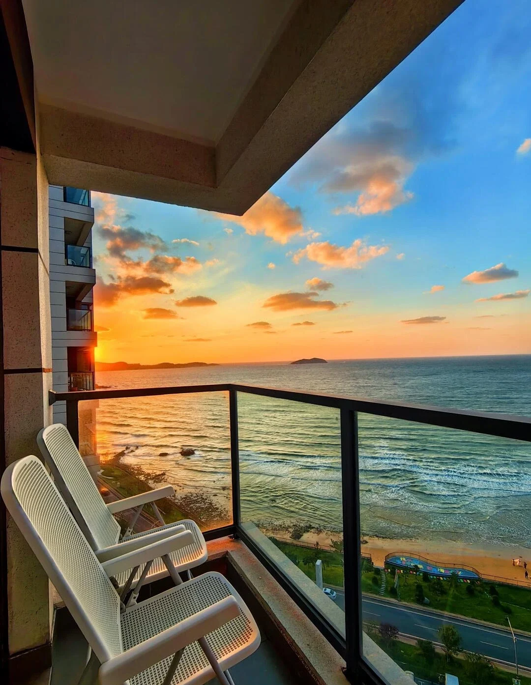 Weihai Ocean View Hotel Balcony Cozy chairs overlooking sea and sunset with waves and scenic coastline view - Where to Stay in Weihai: Best Areas & Hotels 2026 - The China Journey Weihai Ocean View Hotel Balcony Cozy chairs overlooking sea and sunset with waves and scenic coastline view - Where to Stay in Weihai: Best Areas & Hotels 2026 - The China Journey