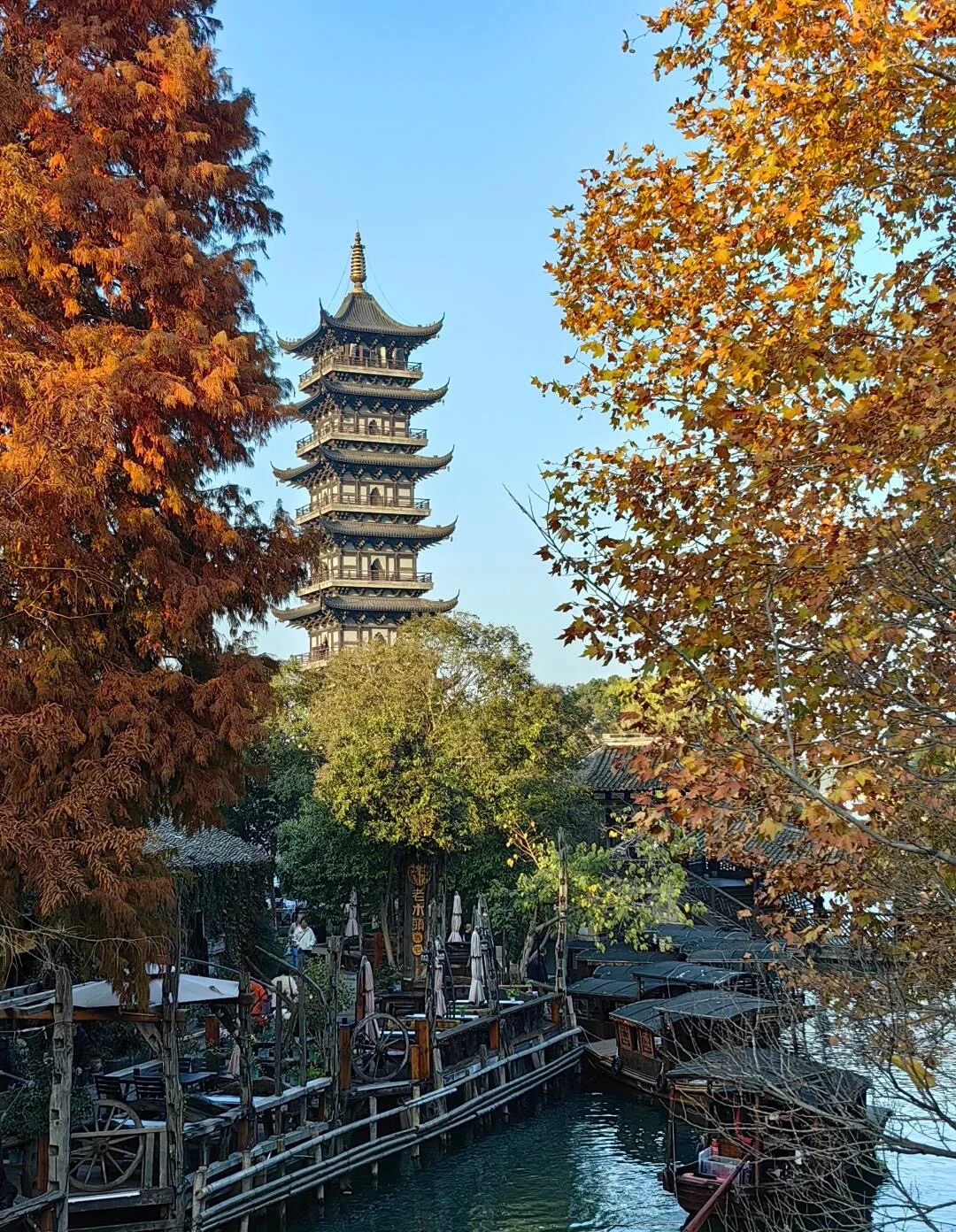 Herfstzicht op een pagode in Wuzhen, met een traditionele pagode tussen kleurrijke herfstbladeren boven een schilderachtig kanaalstadje - Reisgids voor Jiaxing: waterstadjes, routes en tips 2026 - The China Journey Herfstzicht op een pagode in Wuzhen, met een traditionele pagode tussen kleurrijke herfstbladeren boven een schilderachtig kanaalstadje - Reisgids voor Jiaxing: waterstadjes, routes en tips 2026 - The China Journey