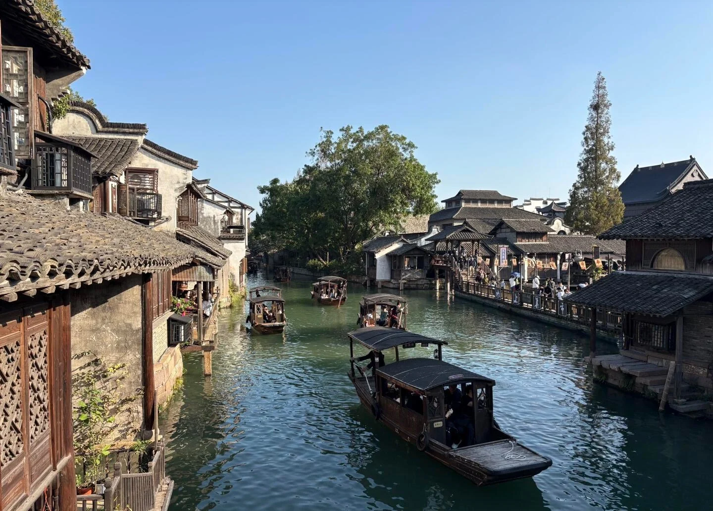 Boottafereel in het waterstadje Wuzhen Xizha, met traditionele houten boten op een historisch kanaal langs klassieke Jiangnan-architectuur - Reisgids voor Jiaxing: waterstadjes, routes en tips 2026 - The China Journey Boottafereel in het waterstadje Wuzhen Xizha, met traditionele houten boten op een historisch kanaal langs klassieke Jiangnan-architectuur - Reisgids voor Jiaxing: waterstadjes, routes en tips 2026 - The China Journey