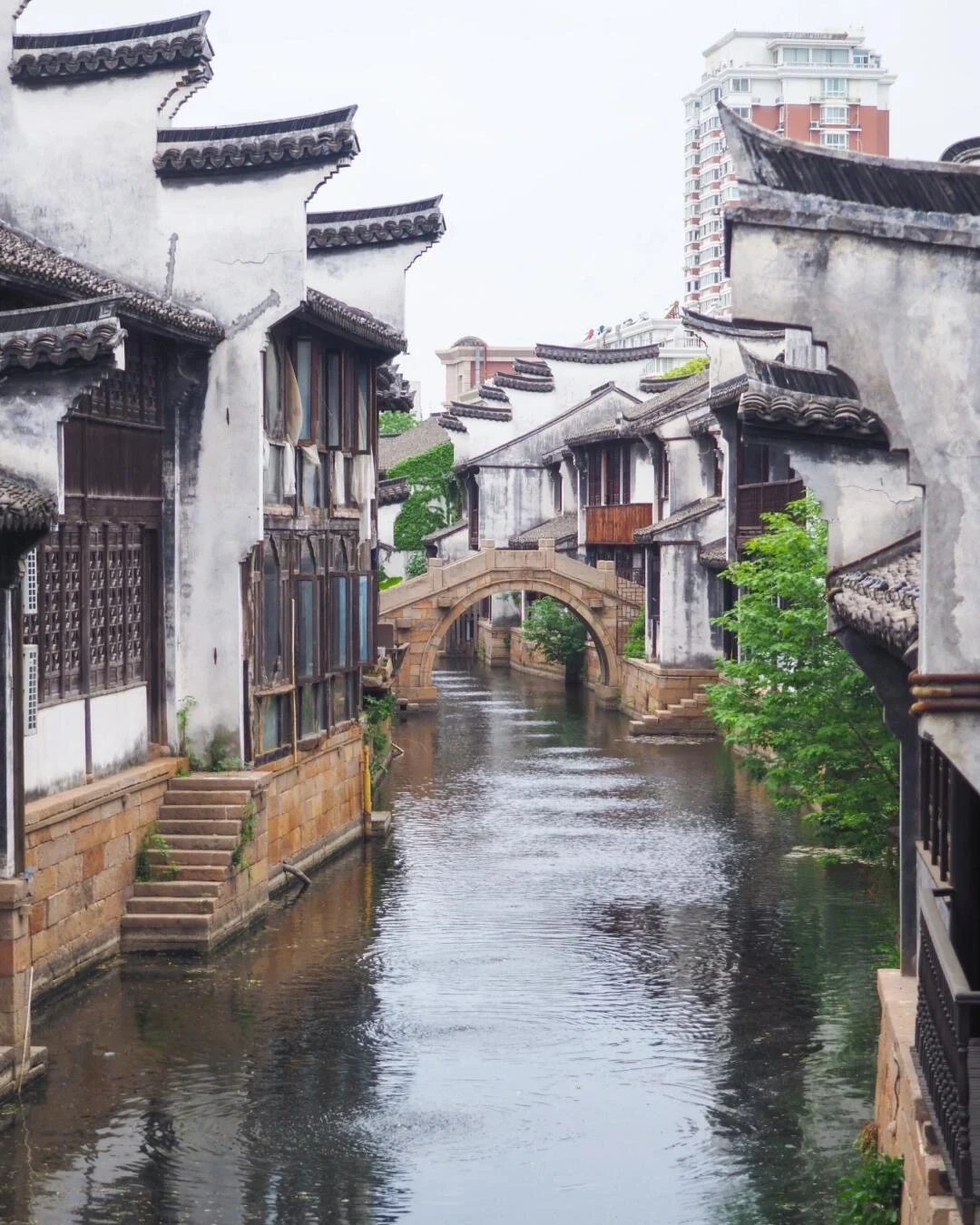 Kanaalzicht in de historische wijk Yuehe, met een rustig kanaal, witte muren, zwarte dakpannen en een boogbrug die authentieke Jiangnan-charme tonen - Reisgids voor Jiaxing: waterstadjes, routes en tips 2026 - The China Journey Kanaalzicht in de historische wijk Yuehe, met een rustig kanaal, witte muren, zwarte dakpannen en een boogbrug die authentieke Jiangnan-charme tonen - Reisgids voor Jiaxing: waterstadjes, routes en tips 2026 - The China Journey